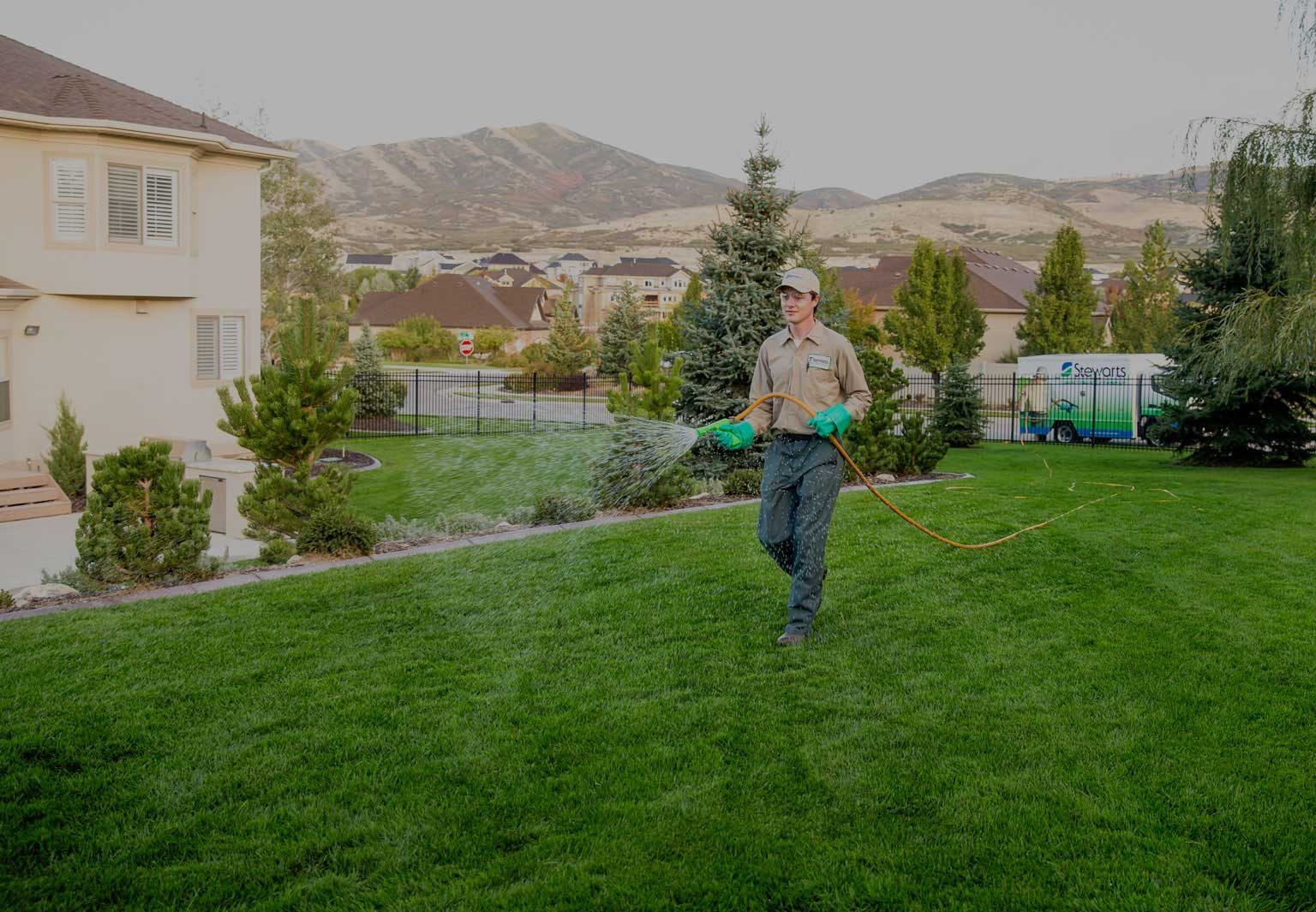technician applying fertilizer to a lawn